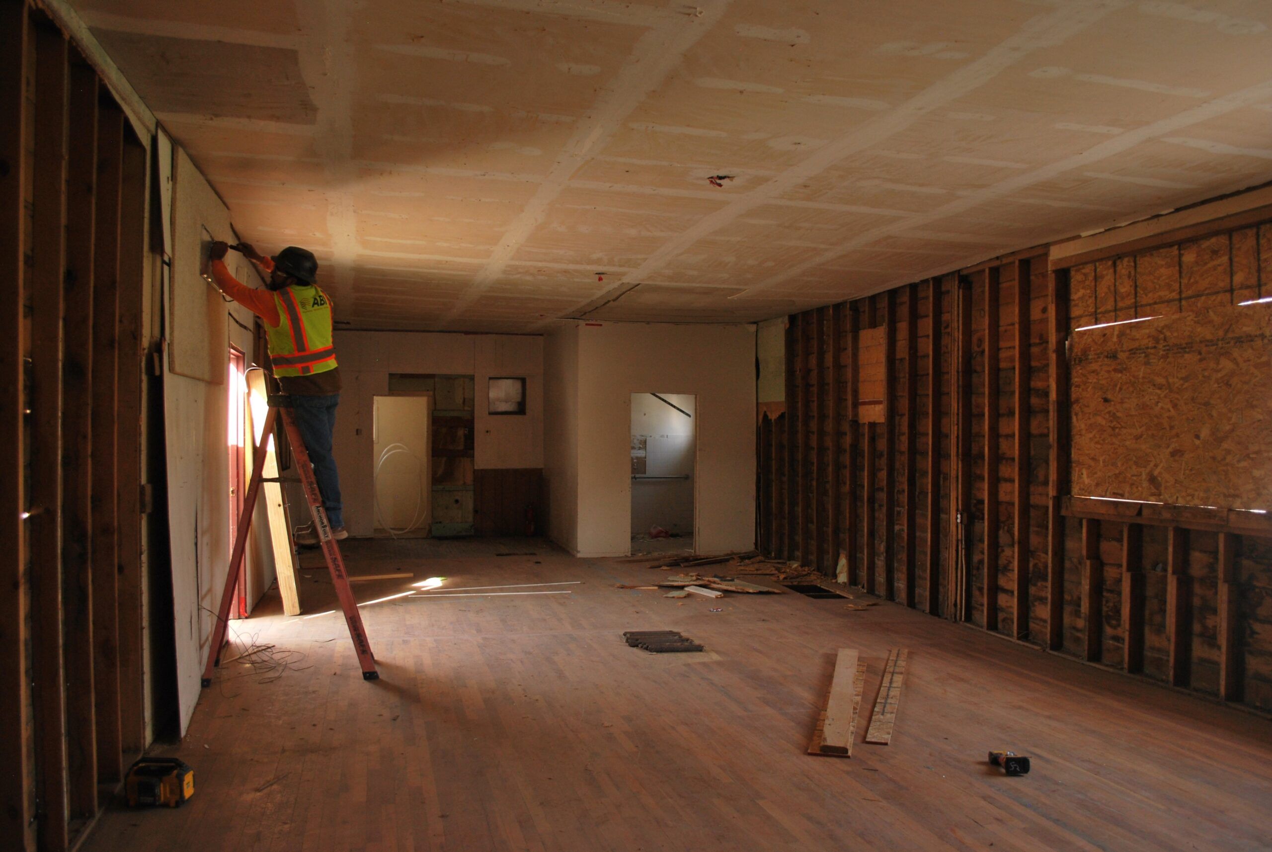 Construction worker in safety gear handling equipment on an active site.